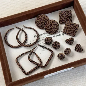 Detailed view of geometric leopard print earrings with flocked velvet texture on a tray