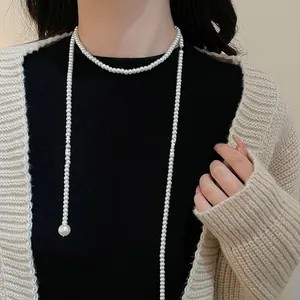 Detailed view of elegant long pearl lariat necklace with large pearl pendant on model