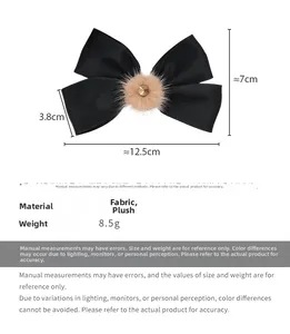 Vista dettagliata del fiocco di raso nero con pompon di peluche e dimensioni precise