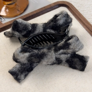 Detail of plush lamb wool shark hair clip with leopard pattern and secure plastic teeth