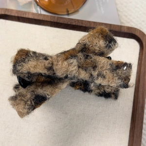 Close-up of leopard print teddy fleece hair claw clip with plush texture for winter