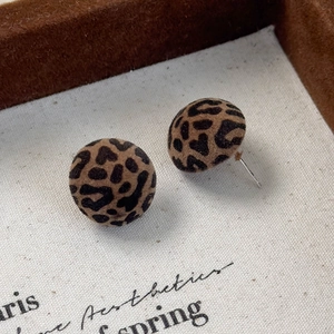 Close-up of vintage flocking leopard print round earrings with a soft velvet texture