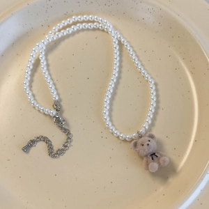 Détail du collier de perles avec pendentif ours en velours et fermoir mousqueton réglable