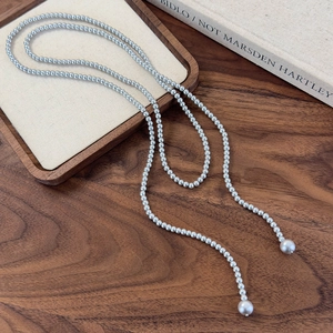 Detail of elegant long silver-gray pearl necklace with tassel lariat design for women
