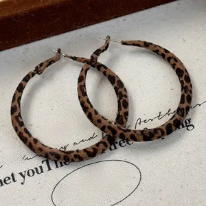 Macro shot of flocked leopard print hoop earrings with vintage velvet texture details
