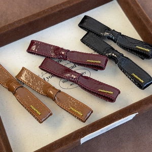 Set of 6 vintage leather bow hair clips in black, burgundy and brown with gold logo details