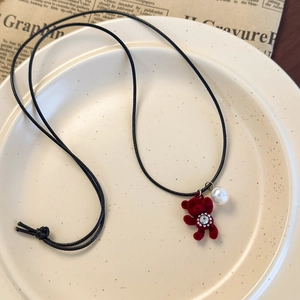 Gros plan du pendentif ours floqué rouge avec cristal de tournesol sur une assiette