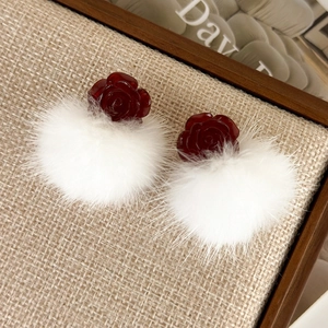 Winter faux fur ball earrings with dark red resin rose studs on beige woven background