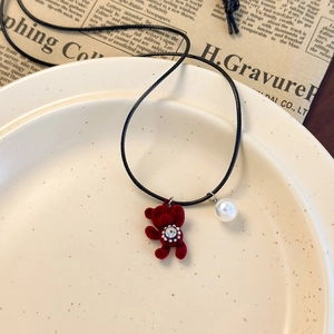 Vue macro d'un pendentif ours rouge avec strass sur un fond de style vintage