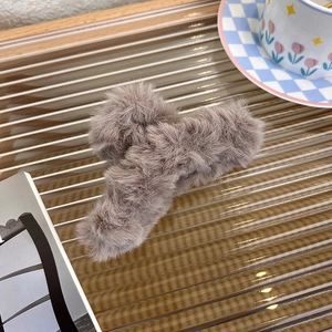 Großaufnahme einer großen kaffeebraunen Plüsch Haarklammer auf einer schicken Glasfläche