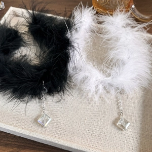 Detail view of vintage choker necklaces with black and white feathers and crystal pendants