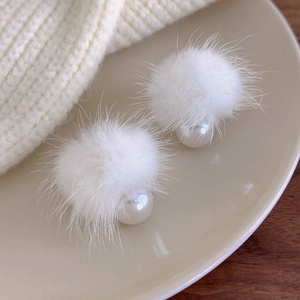 Winter elegant white fluffy faux mink fur ball earrings with pearls on ceramic tray