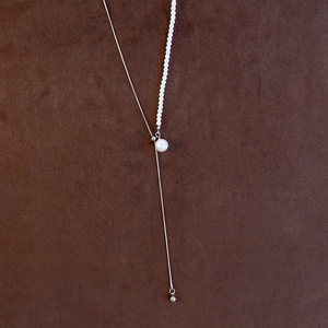 Detail of adjustable pearl necklace with asymmetrical silver snake chain and large pearl drop