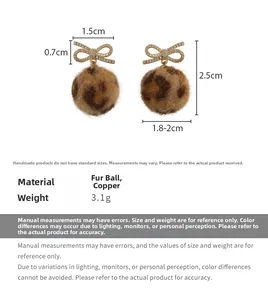 Detail view showing leopard print plush ball earrings with sparkling golden bow size specs