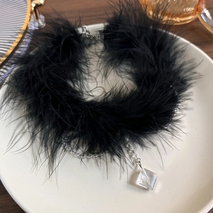 Detail of black feather choker featuring a square crystal pendant and beaded tassels