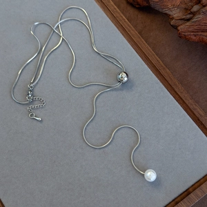 Detailed macro view of adjustable silver snake chain necklace with pearl pendant