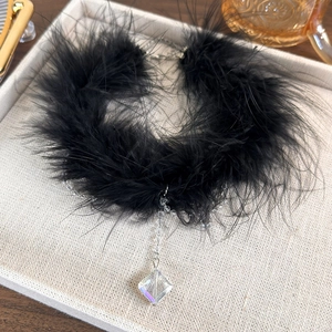 Detailed shot of black feather choker with crystal fringe pendant on display tray