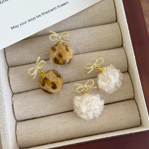 Bowknot plush pompom earrings with leopard print and white fur in a jewelry box