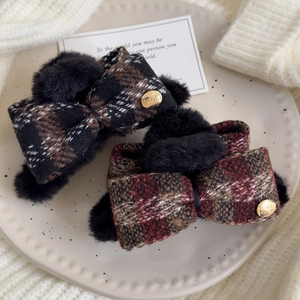 Elegant plaid bow hair claw clip with plush accents and gold emblem in retro winter style