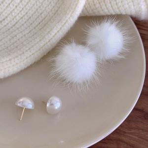 White faux mink fur pom pom earrings with creamy pearls on a ceramic tray for winter