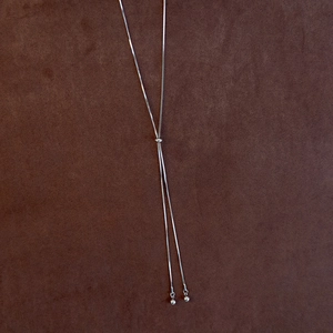 Detailed view of adjustable silver Y-necklace with box chain and spherical pendants