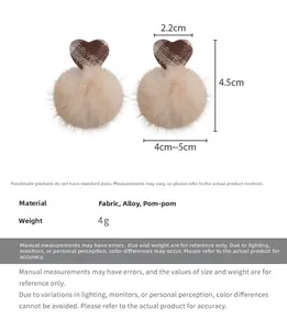 Detail view of brown plaid heart and beige plush ball earrings with size measurements