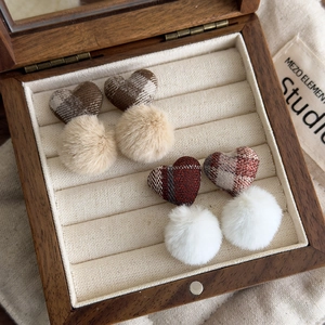 Plaid heart earrings with faux fur pom pom in brown tones on a vintage wooden jewelry box