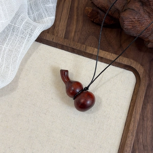 Détail du pendentif gourde en bois vintage avec texture de grain de bois brun-rouge