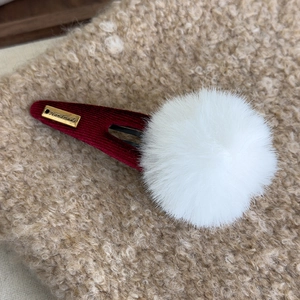 Vue détaillée de la boule de peluche douce et de l'étiquette dorée faite main sur la pince