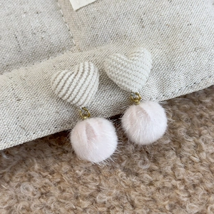 Detail of heart corduroy earrings with soft pink faux fur poms for winter fashion