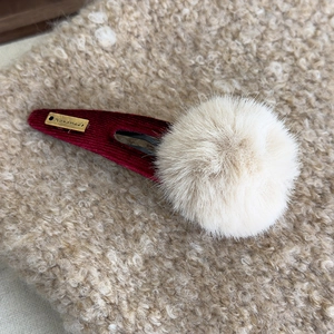 Vue macro de la pince à cheveux en peluche avec texture velours et étiquette dorée