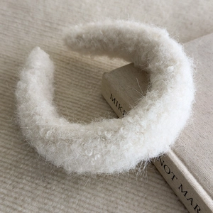 Detail of soft white plush headband showing thick faux fur texture and rounded design