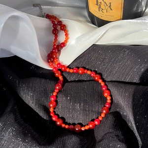 Collier de perles rouges de style chinois moderne avec perles rondes sur du satin