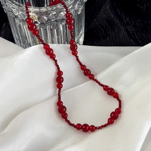 Vintage burgundy beaded necklace with mixed size agate beads on white silk fabric
