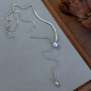 Detail view of adjustable silver pearl necklace with cubic zirconia and snake chain