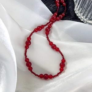 Detail of vintage burgundy beaded necklace with polished agate-style round beads
