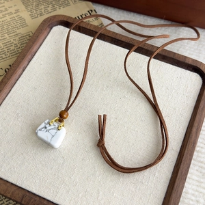 Dettaglio della collana vintage in velluto con ciondolo a forma di borsa in marmo