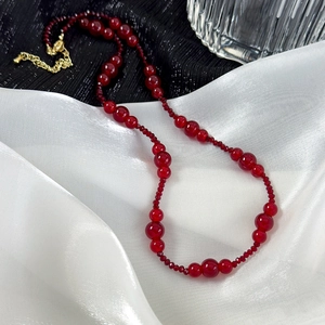 Close-up of vintage wine red beaded necklace with golden adjustable chain and lobster clasp