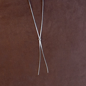 Detail of adjustable silver snake chain necklace with sleek sliding Y-shaped buckle closure