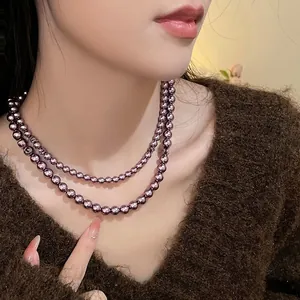 Dettaglio della collana a doppio strato di perle di vetro viola scuro su una modella