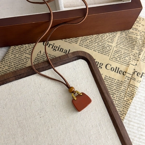 Dettaglio della collana vintage in velluto marrone con pendente in pietra occhio di tigre