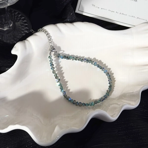 Macro view of blue crystal beads with iridescent finish and silver lobster clasp