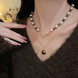 Vue détaillée du collier double rang avec pierres œil de tigre et perles sur un mannequin