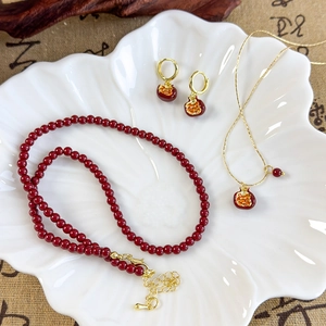 Elegant red pomegranate jewelry set with beaded necklace and matching gold earrings