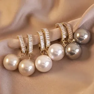 Orecchini pendenti in oro con zirconi e grandi perle rotonde nei colori bianco e grigio