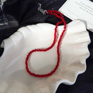 Detailed view of red faceted crystal beads necklace with silver lobster clasp on tray