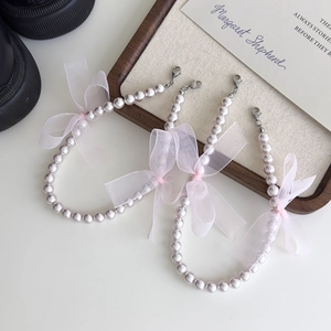 Détail de chaînes de chaussures en perles violet clair avec nœuds en organza rose et clips