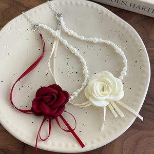 Set choker camelia con perle e nastri di rose in raso rosso intenso e color crema