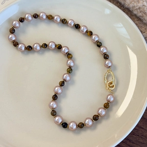 Détail du collier de perles roses et oeil de tigre brun avec fermoir doré élégant