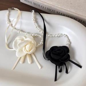 Eleganti collane di perle con fiori di camelia neri e beige e nastri di seta da donna